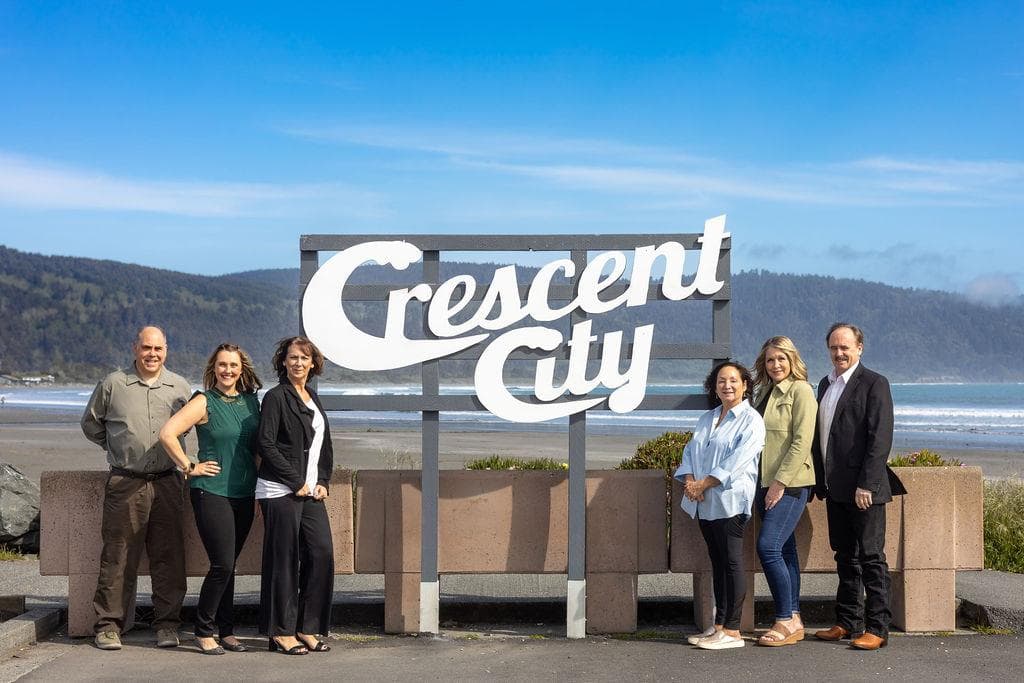 The Finigan Real Estate team at the Crescent City sign